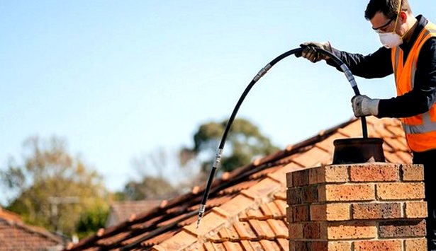 Rod lowered into a chimney pot from the roof